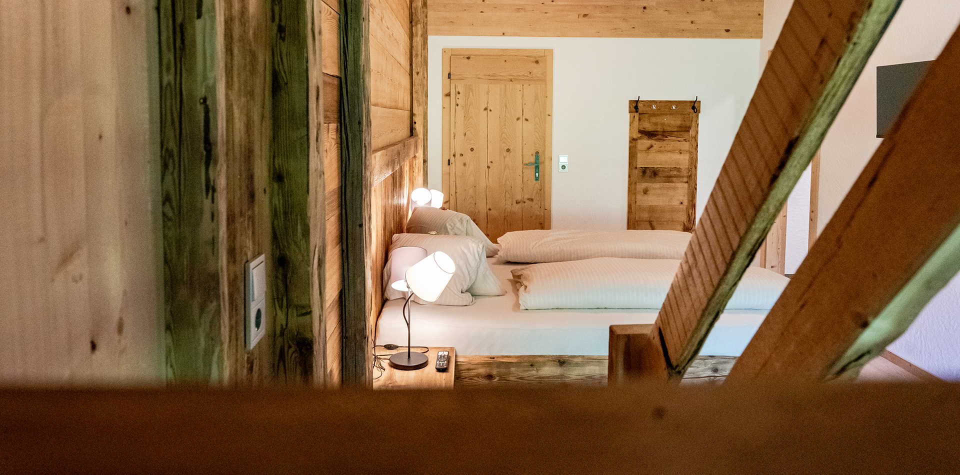 berggasthof-steckholzer-familienzimmer-blick-von-treppe-auf-doppelbett © Tourismusverband Wipptal / Helena Beeremeister